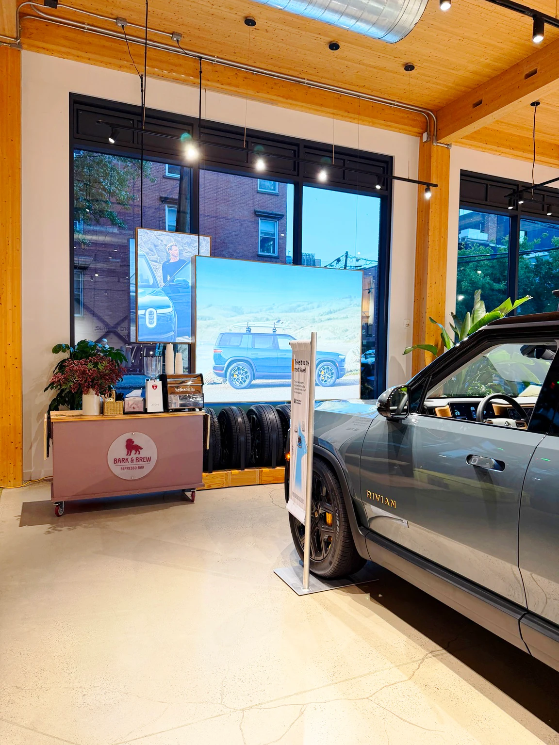 Bark & Brew espresso cart at Rivian Williamsburg with a Rivian vehicle in the showroom
